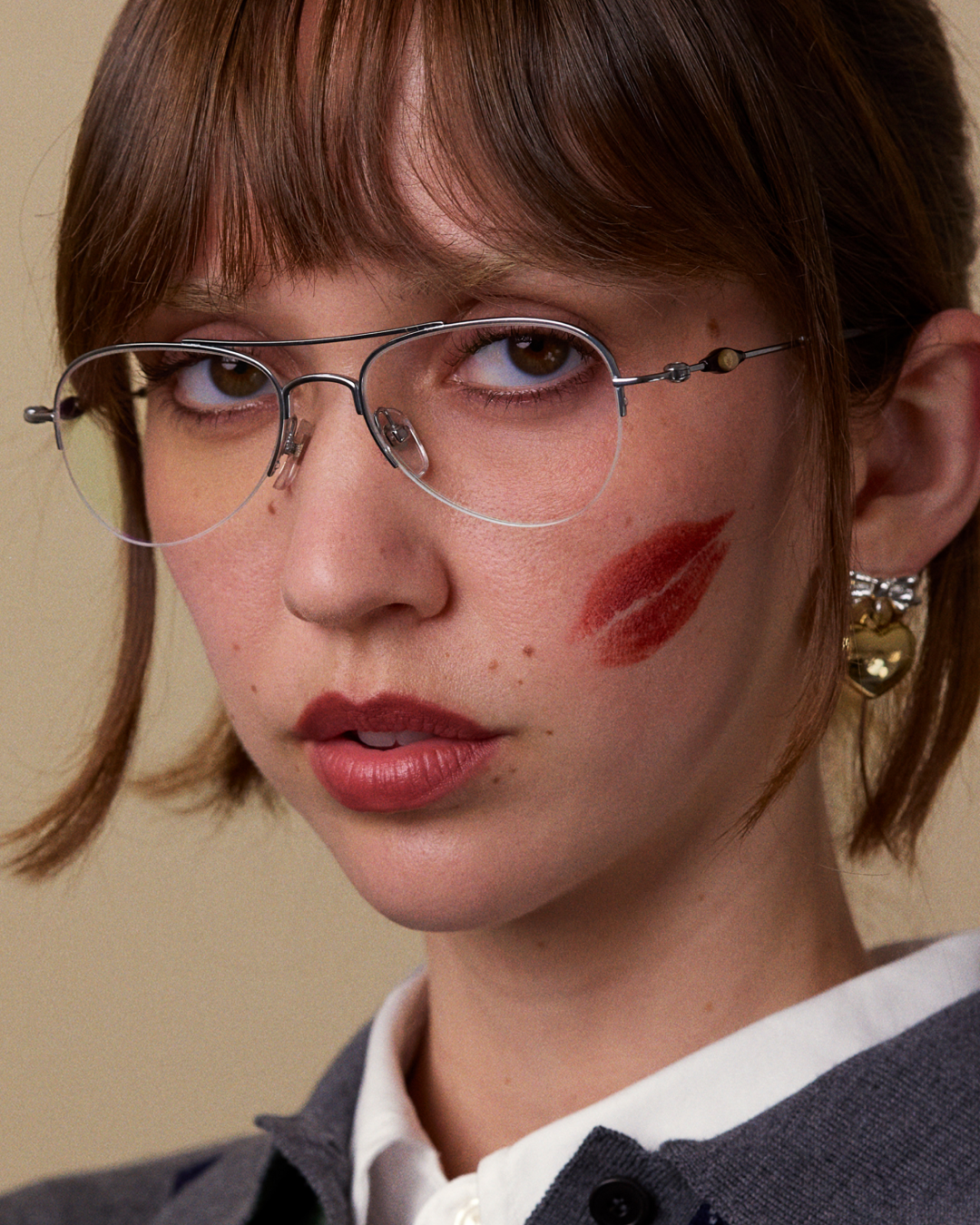Bonnie Clyde Autobio aviator opticals in silver titanium with blue light filtering lenses and exploding heart acetate bead detailing on the arms, on a model's face.