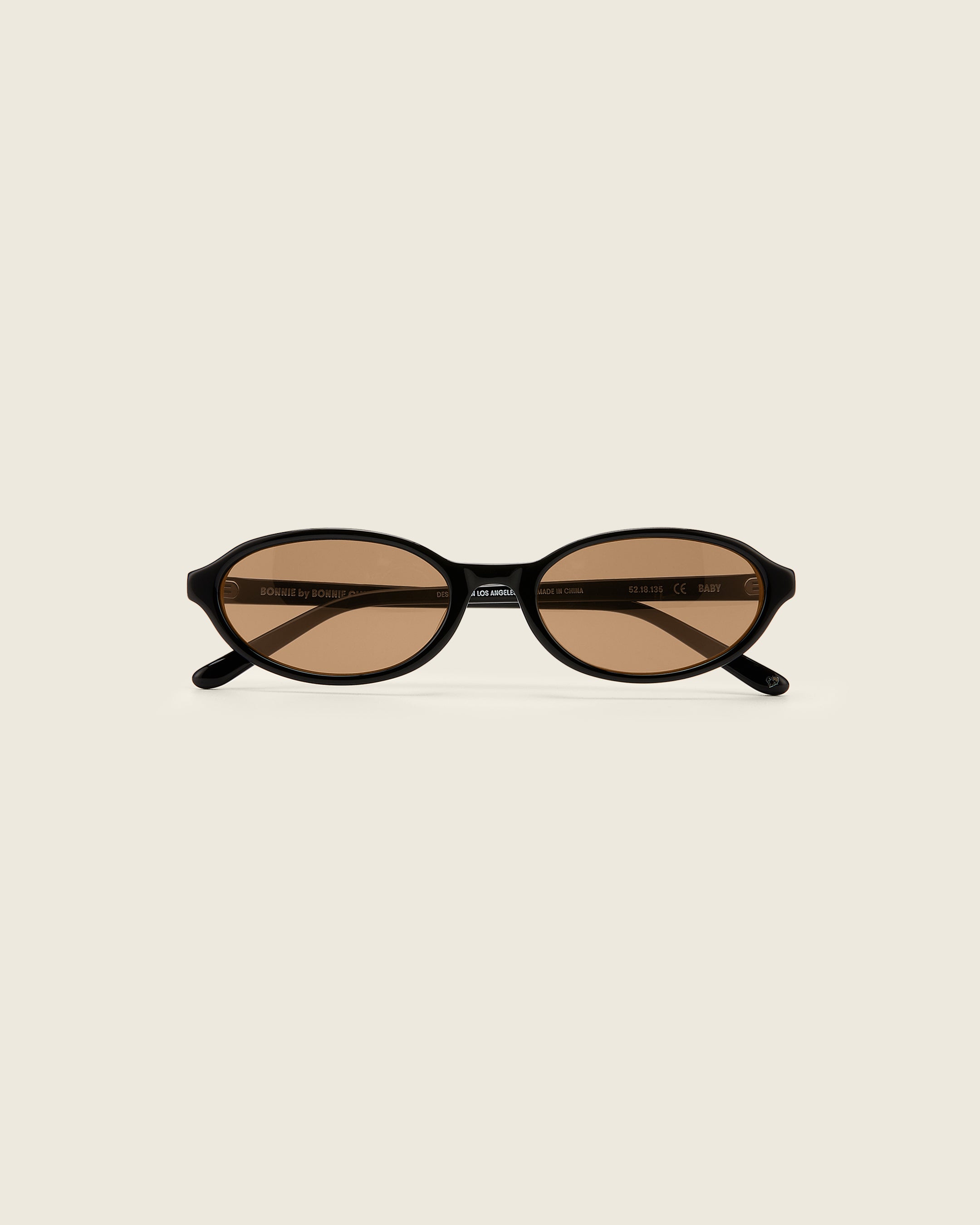 Bonnie Clyde Baby oval sunglasses in black acetate with brown lenses and double heart detailing on the arms, front view
