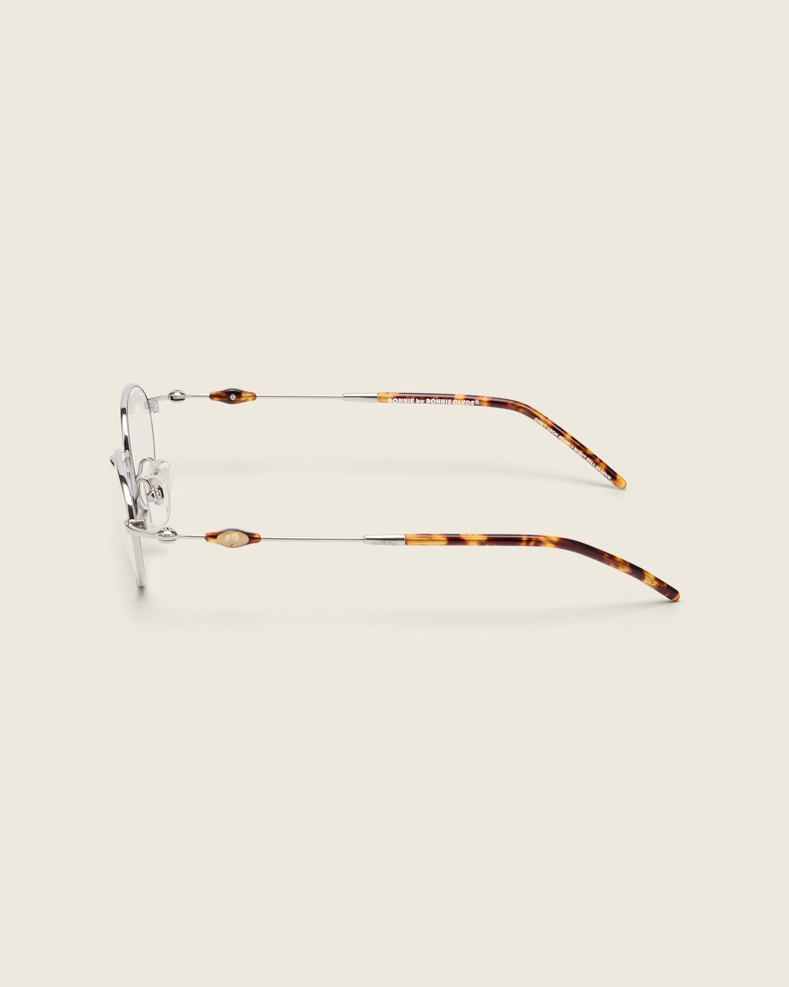 Slim, oval silver titanium frames with adjustable nose pads and lightweight acetate arm temple. Side view.