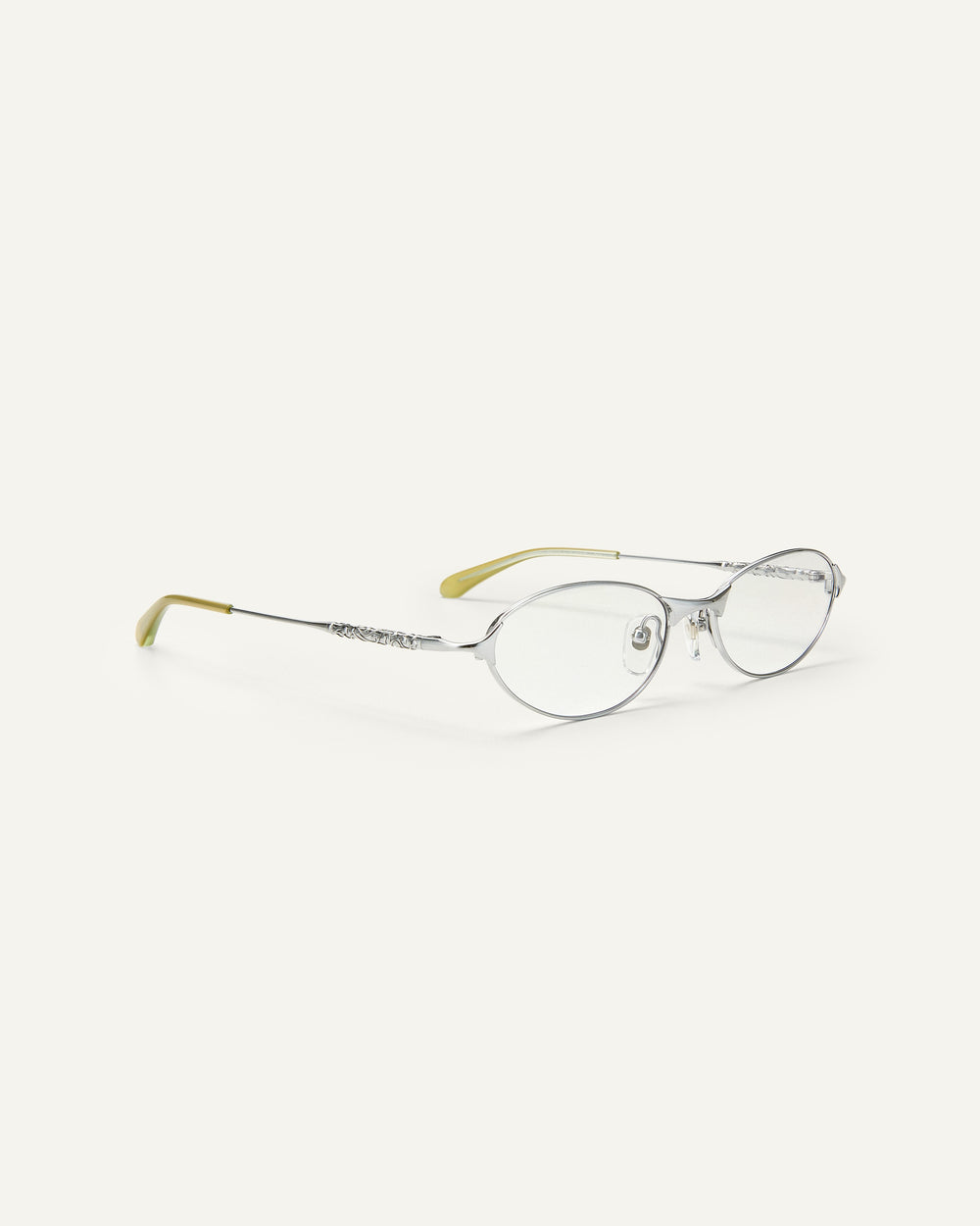 Quarter shot of Bonnie Clyde Intro eyeglasses in silver titanium frames with green acetate details and clear lenses.