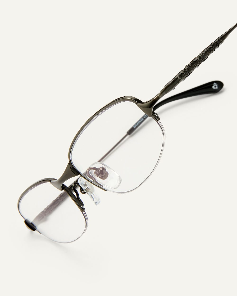 Side shot of Bonnie Clyde Outro eyeglasses in gunmetal titanium frames with black acetate details and clear lenses.