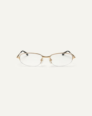 Face shot of Bonnie Clyde Outro eyeglasses in gold titanium frames with black acetate details and clear lenses.