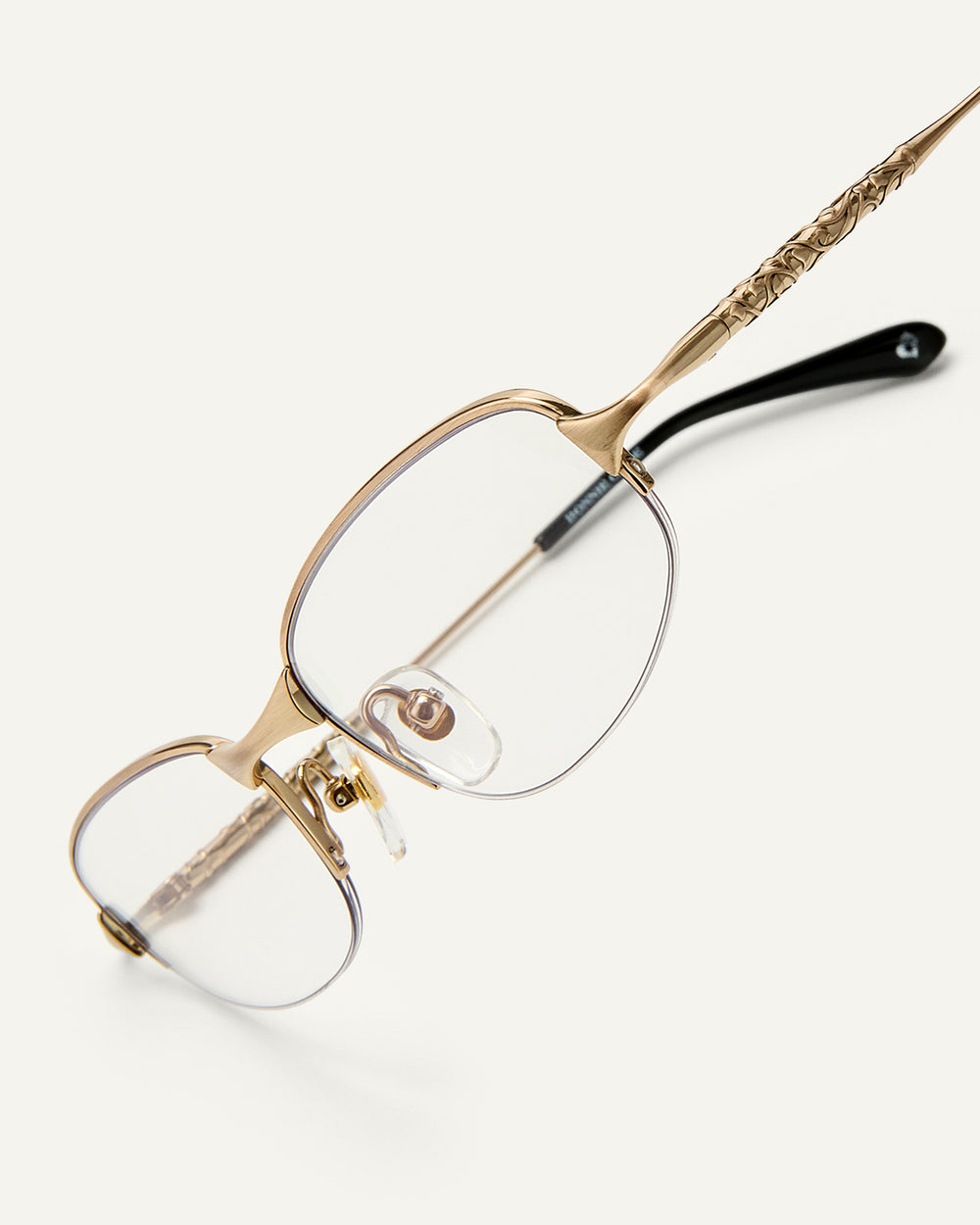 Side shot of Bonnie Clyde Outro eyeglasses in gold titanium frames with black acetate details and clear lenses.