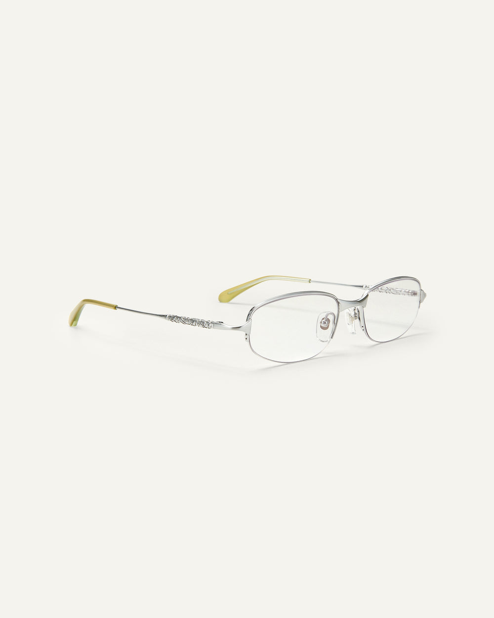 Quarter shot of Bonnie Clyde Outro eyeglasses in silver titanium frames with green acetate details and clear lenses.