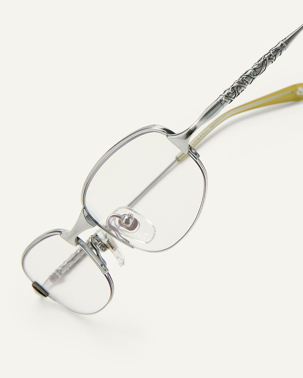 Side shot of Bonnie Clyde Outro eyeglasses in silver titanium frames with green acetate details and clear lenses.