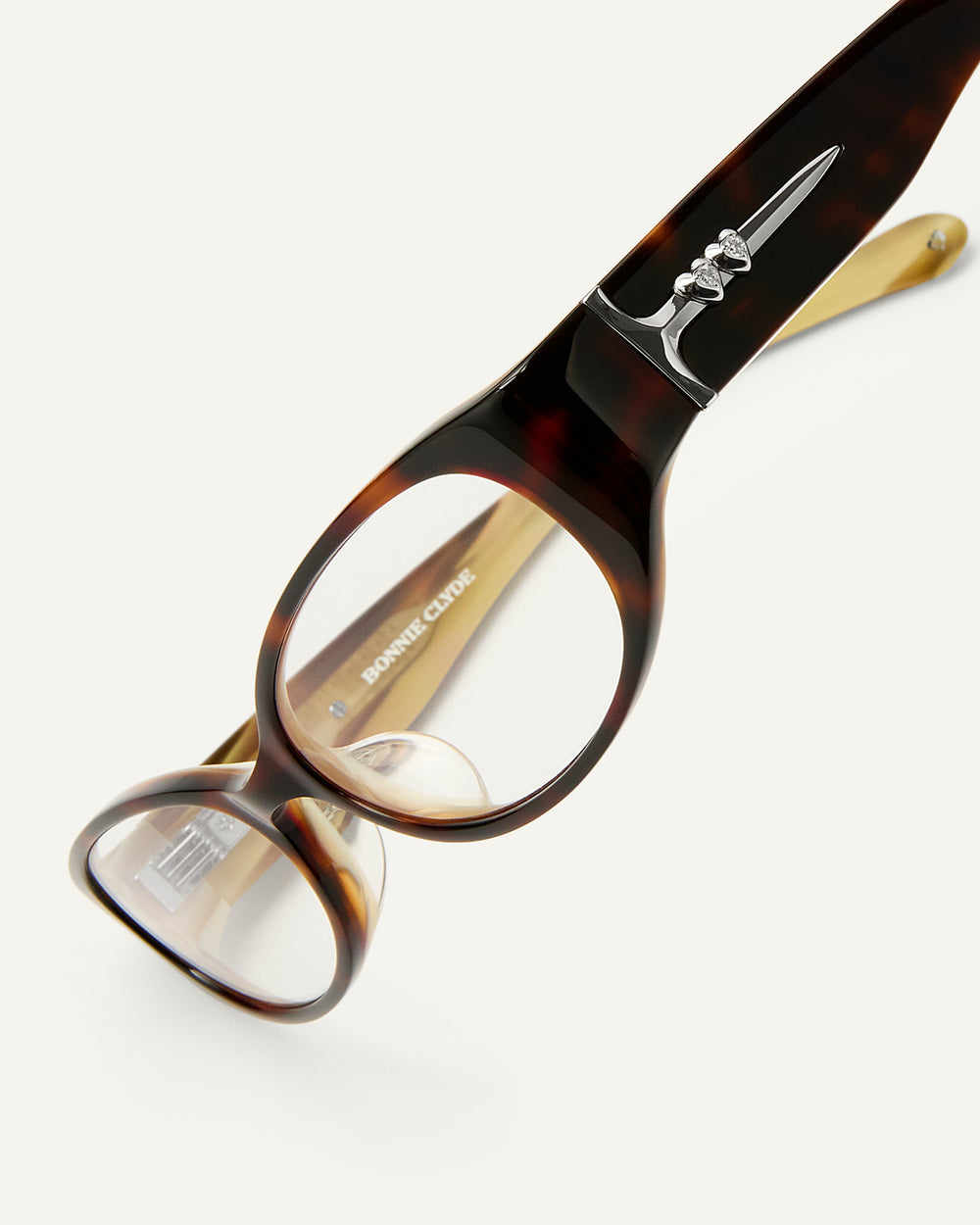Side shot of Bonnie Clyde Precious eyeglass in layered tortoise frames with clear lenses.