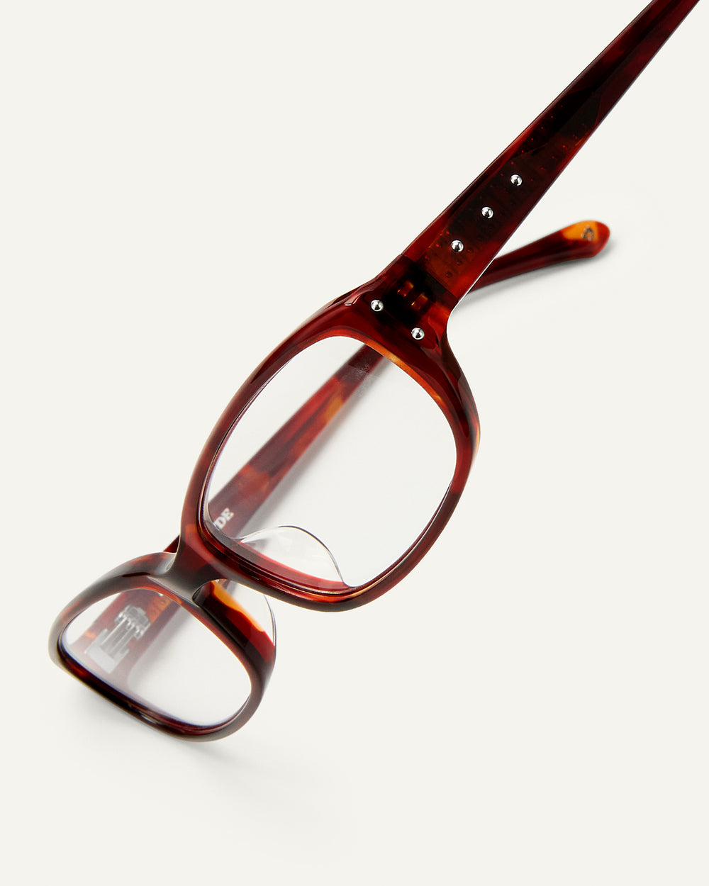 Side shot of Bonnie Clyde Triplet eyeglasses in red tortoise frames with clear lenses.